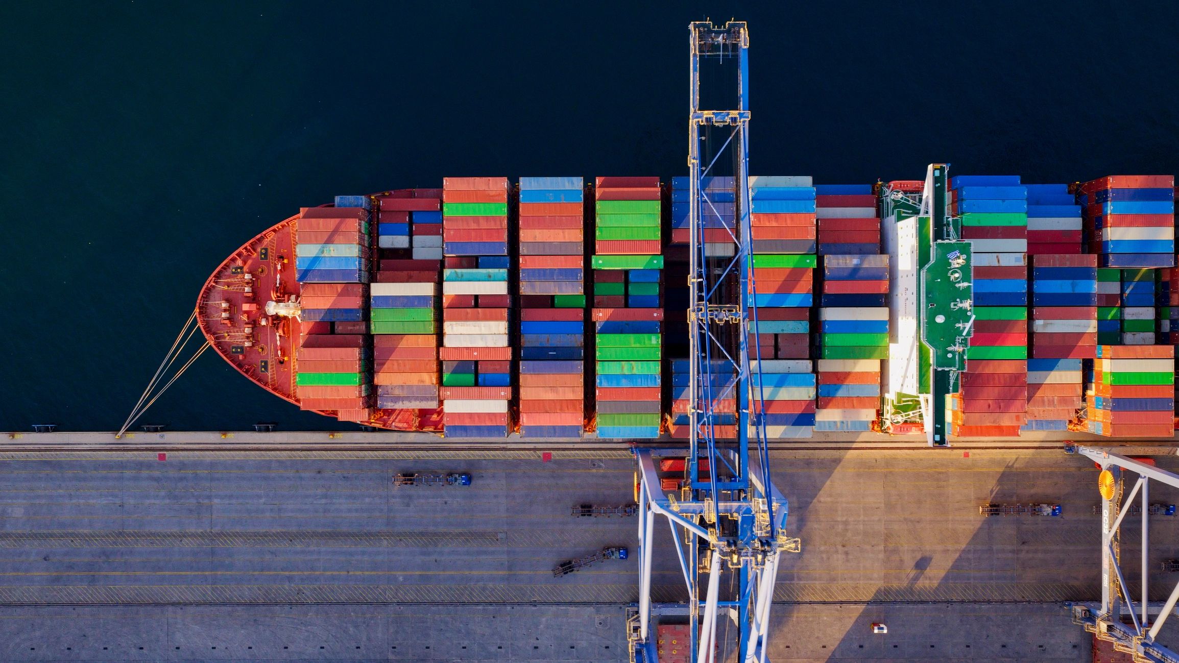 Container ship docking at industrial port importing cargo